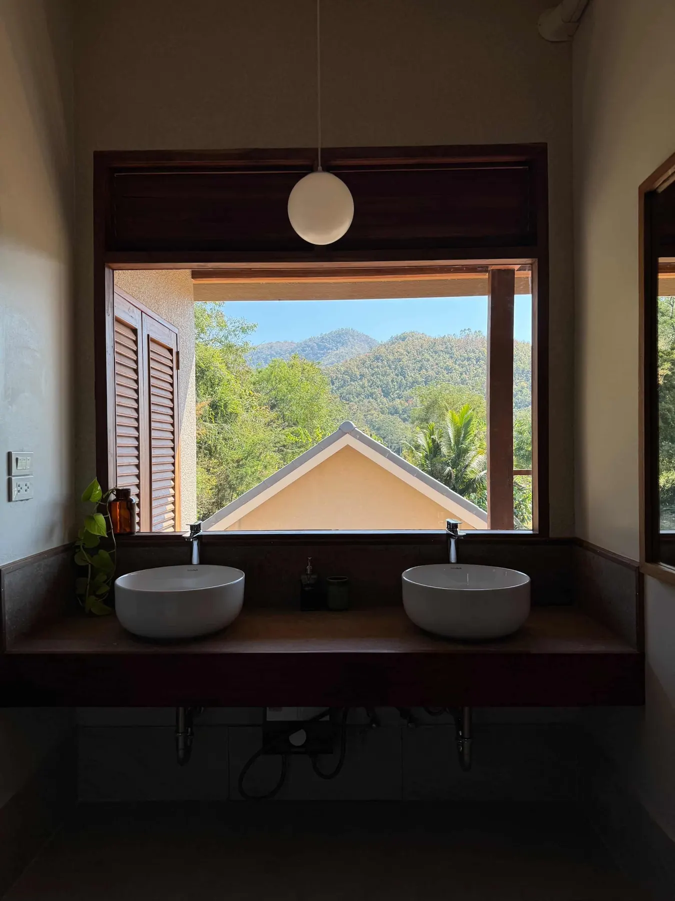 Two stone basins under a window that frames the mountains